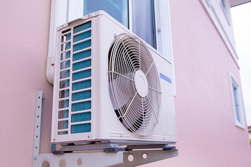 External air conditioner compressor unit are installed on the outside wall of the building.