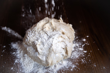 mixed piece of fresh dough for buns and pie on a dark background