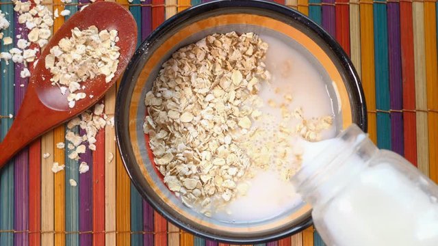 high angle view of milk pouring on oats for breakfast 
