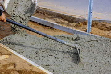 Construction process in the making of freshly pouring cement during sidewalk upgrade