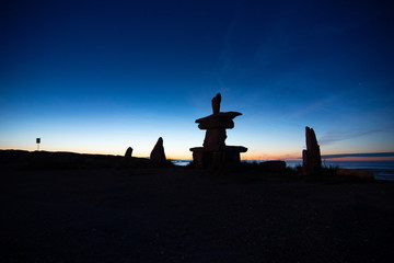 iconic churchill manitoba inukshuk after sunset with the glow of twilight