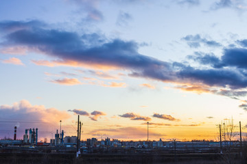 Naklejka premium sunset over industrial city orange light factory