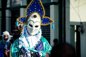 Fototapeta na wymiar closeup person in original pied costume walks by city street at dominican carnival