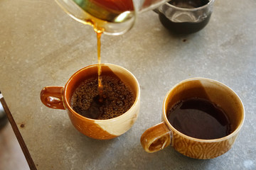 Black coffee​ water​ drop to​ the​​ coffee​ cup​ and Black coffee in a cup on the table.