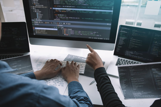 Professional development programmer cooperating meeting programming website working a software in office room.