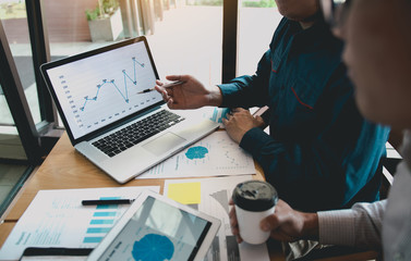 Business partnership pointing to graph the company financial statements report and profits earned...