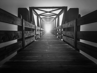 Eerie image of an old truss footbridge on a dark foggy morning at Tims Ford State Park.