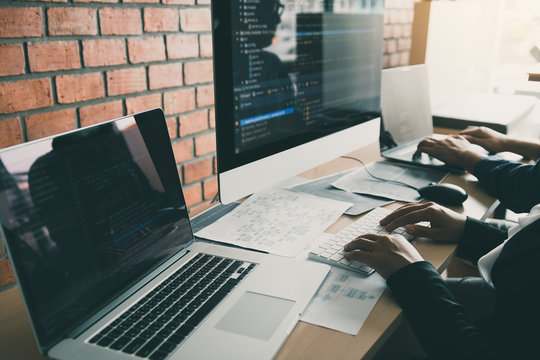 Two partnerships developing programming and coding technologies working on laptop and analyzing together.