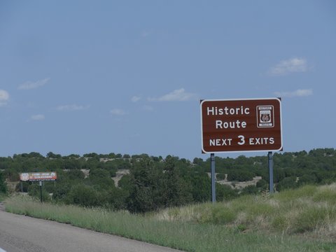 Directional signs on the road with directions to the exit for Route 66 highway in New Mexico.