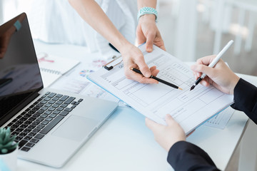 Business woman send document to manager in suit for signature on the desk. Business concept.