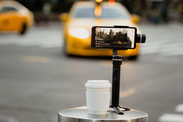 Phone with stabilizer, tripod, gimbal. Taking pictures and live video in New York city. Vlog, video blogging, street photography concept. Copyspace