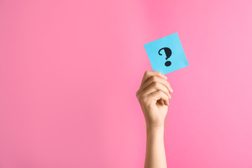 Woman holding note with question mark on pink background, closeup. Space for text