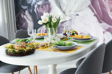 Festive Easter table setting with beautiful white tulips and eggs indoors