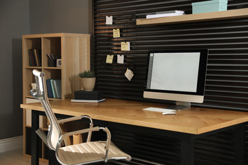 Comfortable workplace with office chair and computer on wooden table