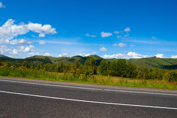 asphalt road and green hills on horizon