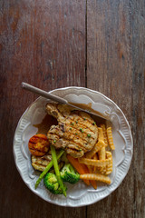 Black pepper pork chop in white plate on wooden table