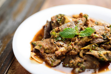 Local Thai food (Tub Wan), spicy pork liver salad on white plate