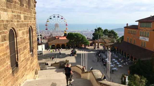 Eleveated view over Barcelona with a ferris wheel and amusement park in the foreground