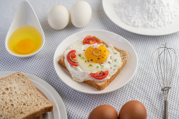 Bread placed with a fried egg with tomatoes, tapioca flour and sliced ​​spring onions.