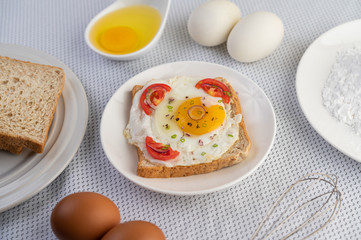 Bread placed with a fried egg with tomatoes, tapioca flour and sliced ​​spring onions.