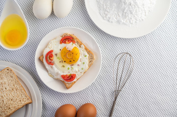 Bread placed with a fried egg with tomatoes, tapioca flour and sliced ​​spring onions.