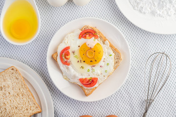 Bread placed with a fried egg with tomatoes, tapioca flour and sliced ​​spring onions.