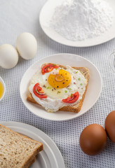 Bread placed with a fried egg with tomatoes, tapioca flour and sliced ​​spring onions.