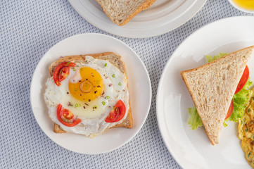 Omelette, fried egg and sandwiches are in a color palette on a white background.
