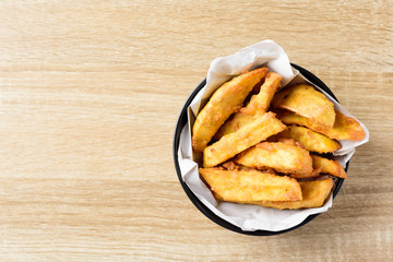 Deep-fried sweet potato in a bowl on wooden table, Delicious homemade snack