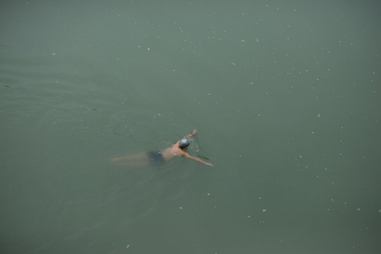 Man Swimming In A Murky River In China