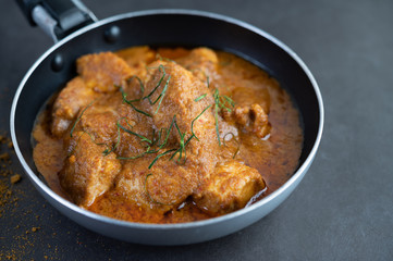 Massaman curry in a frying pan with spices on the cement floor