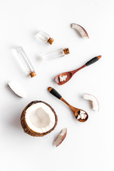 Coconut cosmetics. Organic oil in small bottles on white background top-down