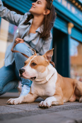  A beautiful young girl on the street taking photos of herself and her dog