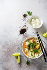 Wheat noodles, balls of mozarella and vegetables in a white plate