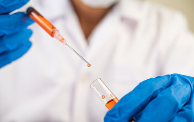 Scientists wearing masks and gloves Holding a syringe with a vaccine to prevent covid-19