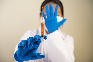 Scientists wearing masks and gloves Holding a syringe with a vaccine to prevent covid-19