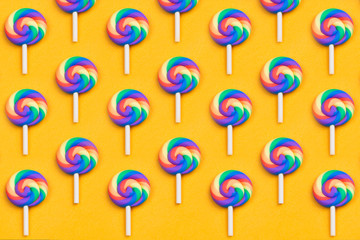 Lollipops are in a row. spiral candy pattern. lots of sweets on a yellow background. festive decoration