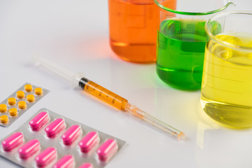 Medicine panels, syringes and beakers are placed on the floor.