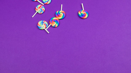 Colorful candies. lollipops isolated on purple background. festive concept. copy space