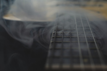 Acoustic guitar in smoke close up. musical instrument. strings on the guitar neck