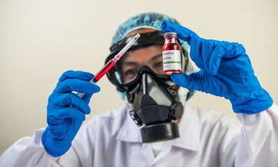 Scientists wearing masks and gloves Holding a syringe with a vaccine to prevent covid-19