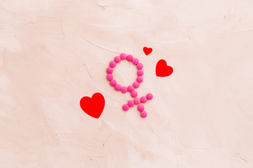 Gender Venus symbol made of contraceptive pills, near heart sign - woman health concept - on beige background top-down copy space