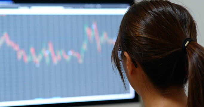 Woman look at the stock market graph at office