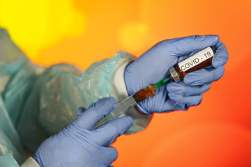 A blue-gloved medical worker draws an ampoule into a syringe. Medical vaccination against coronavirus flu concept. injection bottle for medical glass vials. COVID pandemic