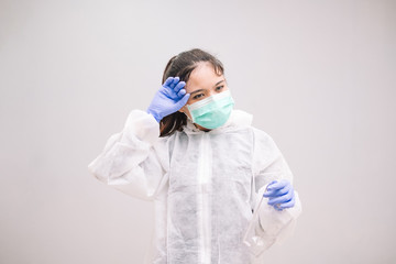 Tired Young Nurse wearing disposable coverall with mask and safety googles thinking tired and...