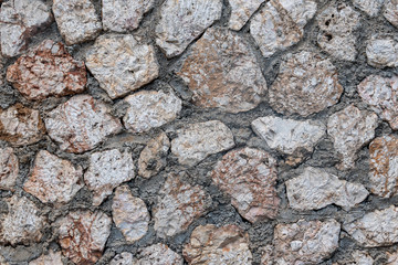 closeup shot of a rough stone wall highlighting it's intricate pattern and texture