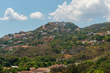 Fototapeta na wymiar a village filled with houses populates a hill on a bright sunny day