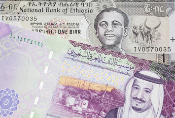 A one birr note from Ethiopia in macro with a five riyal Saudi Arabian bank note close up