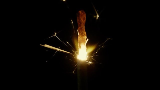 Bengal fire sparkle burning in the dark on black background, 4k super slow motion