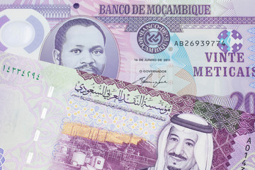 A purple, twenty metical note from Mozambique close up with a red, one hundred Saudi Arabian riyal...